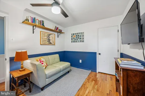 a living room with furniture and wall paintings