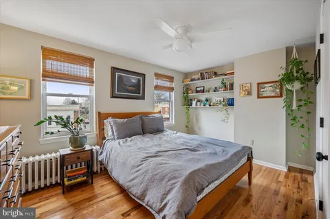 a bedroom with a bed and a refrigerator