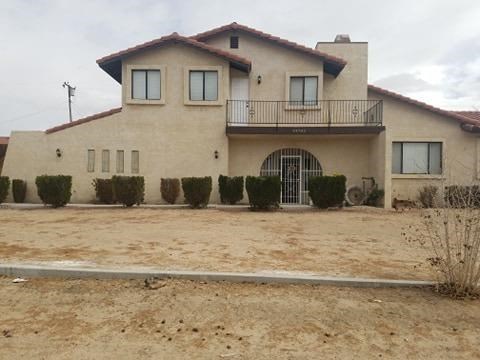 14703 Apple Valley Road Apple Valley, CA 92307 - Photo 1 of 1 a front view of a house with a yard