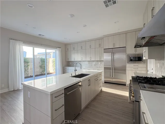 a large kitchen with a large window and stainless steel appliances