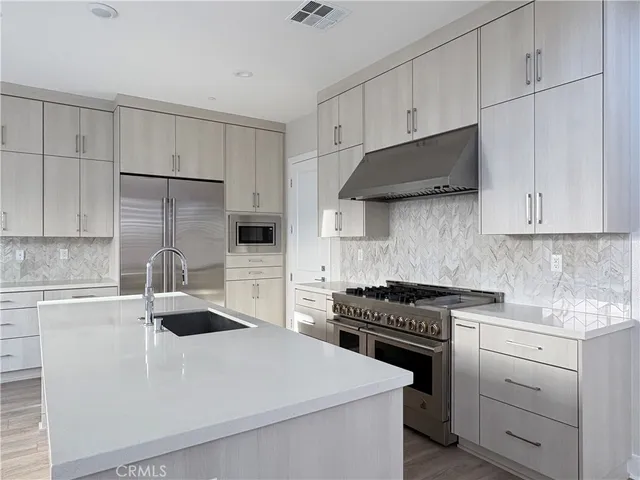 a kitchen with granite countertop a sink a stove and cabinets