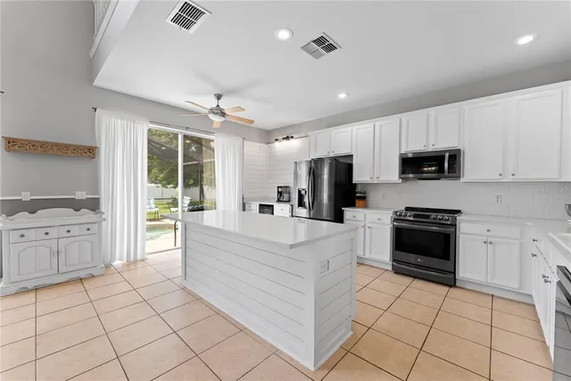 a large white kitchen with cabinets and steel stainless steel appliances