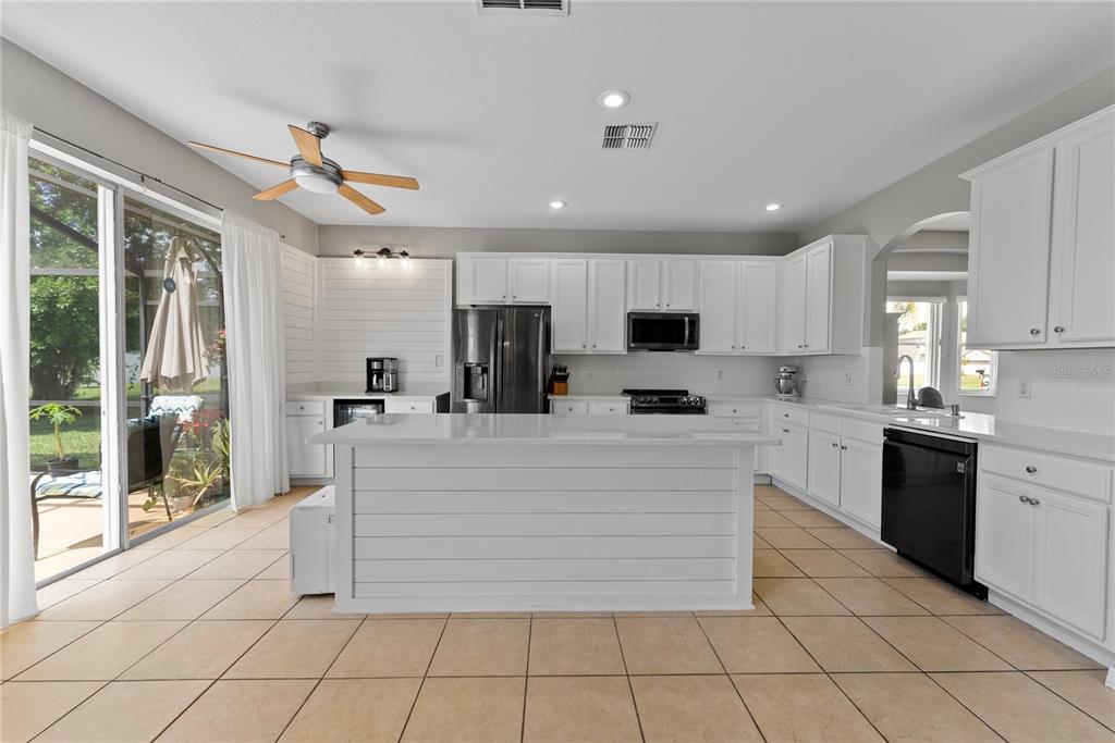 3149 Twisted Oak Loop Kissimmee, FL 34744 - Photo 13 of 52 a large white kitchen with granite countertop a large window and white stainless steel appliances