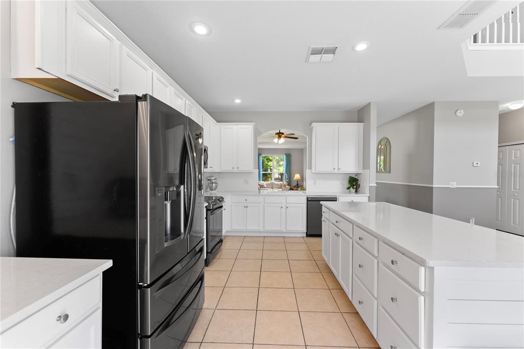 3149 Twisted Oak Loop Kissimmee, FL 34744 - Photo 14 of 52 a kitchen with white cabinets and stainless steel appliances