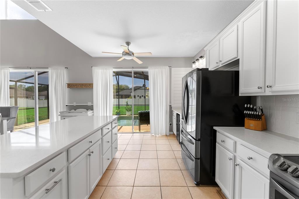 3149 Twisted Oak Loop Kissimmee, FL 34744 - Photo 15 of 52 a kitchen with stainless steel appliances a refrigerator sink and cabinets