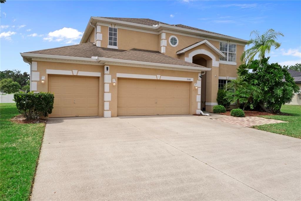 3149 Twisted Oak Loop Kissimmee, FL 34744 - Photo 2 of 52 a front view of a house with a yard and garage