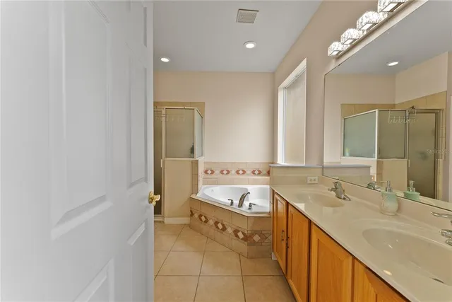 a spacious bathroom with a tub sink and mirror