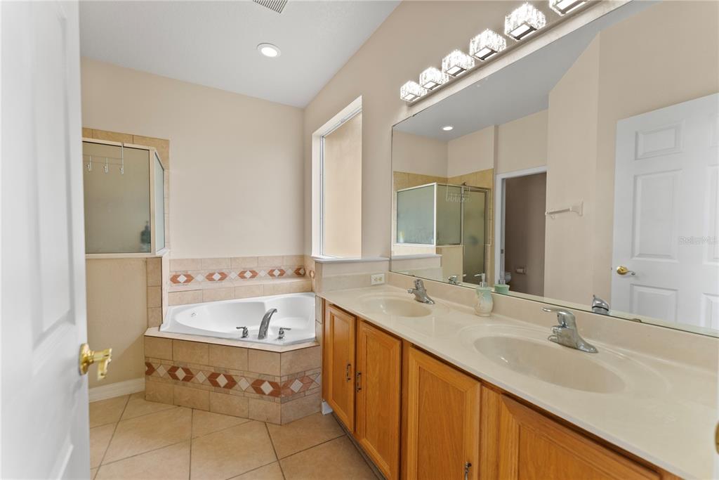 3149 Twisted Oak Loop Kissimmee, FL 34744 - Photo 22 of 52 a spacious bathroom with a double vanity sink mirror and bathtub