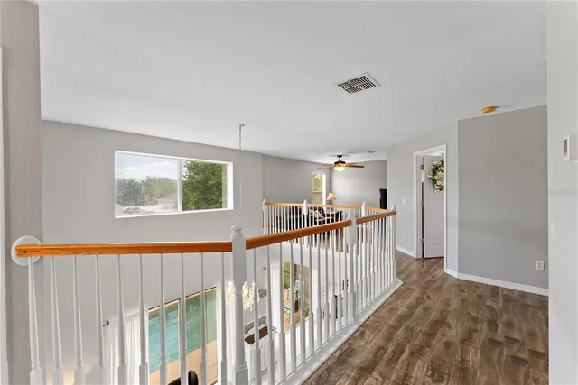a view of a hallway with wooden floor and stairs