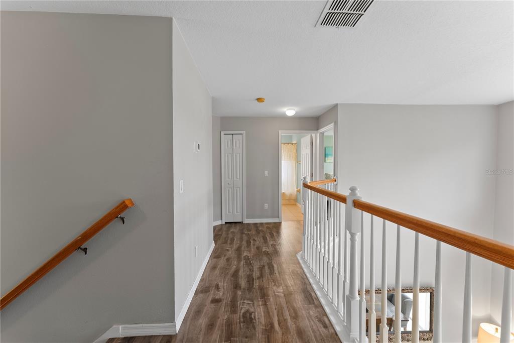3149 Twisted Oak Loop Kissimmee, FL 34744 - Photo 27 of 52 a view of a hallway with wooden floor and stairs