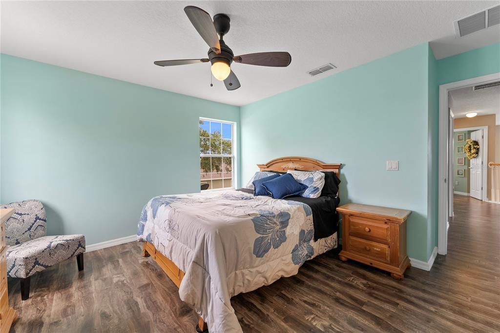 3149 Twisted Oak Loop Kissimmee, FL 34744 - Photo 35 of 52 a bedroom with a bed and wooden floor