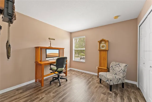a bedroom with two beds and wooden floor