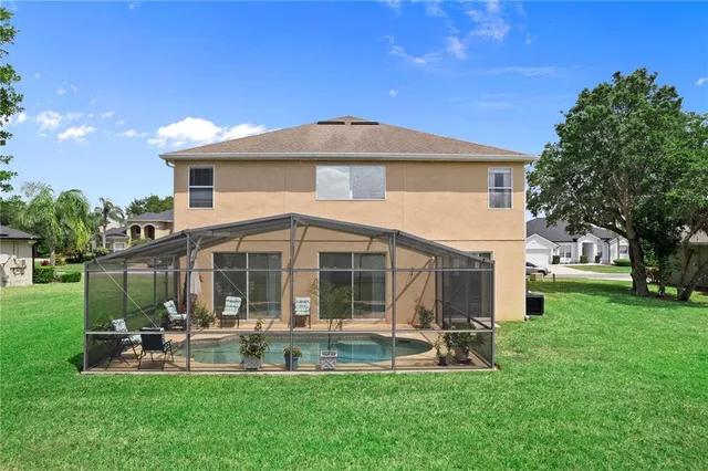 an aerial view of a house with a yard and large trees