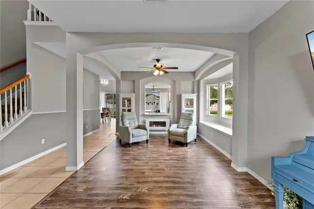 a living room with furniture large window and wooden floor