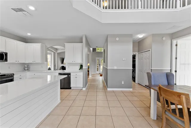 a large white kitchen with a refrigerator a stove a sink and a cabinets