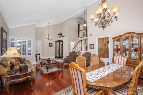 a living room with furniture a chandelier and a dining table