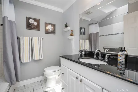 a bathroom with a granite countertop sink mirror vanity and toilet