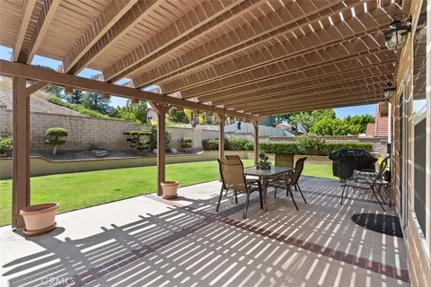 a view of a patio with a table chairs and a backyard