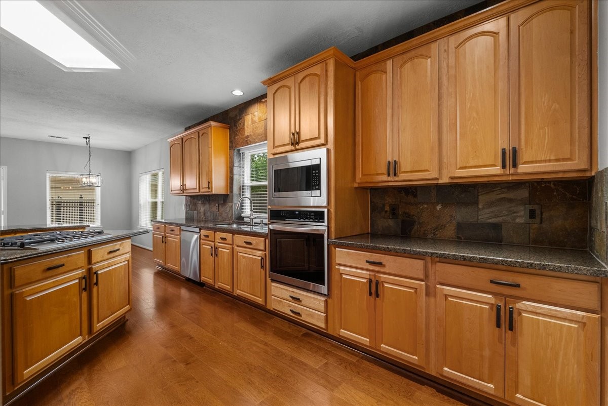 2876 Match Point Lane Friendswood, TX 77546 - Photo 9 of 45 This is a chef's dream! With blond oak cabinets, upgraded stainless steel appliances, granite countertops and stone backsplash, this kitchen is the perfect place to entertain or gather.