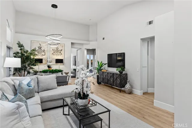 a living room with furniture a flat screen tv and a view of kitchen