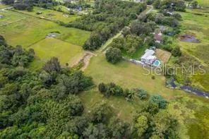 an aerial view of residential houses with outdoor space and trees