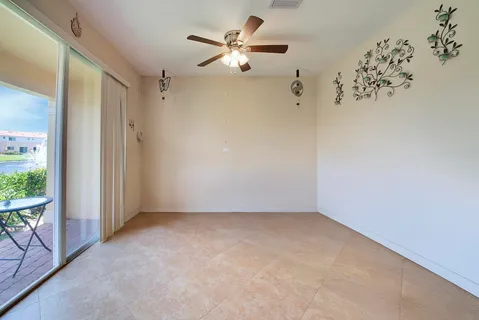 an empty room with a ceiling fan and a window