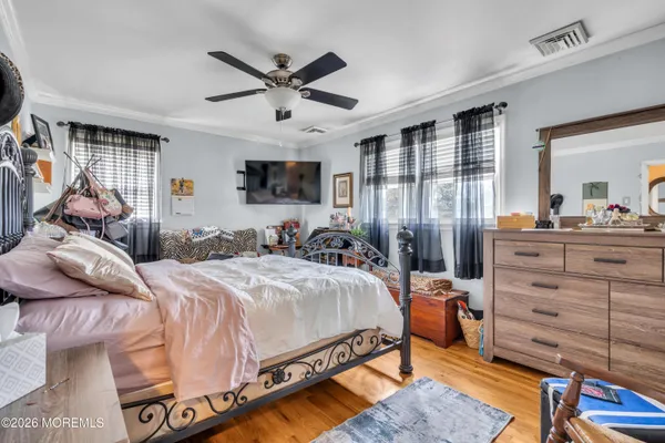 a bedroom with a bed and wooden floor