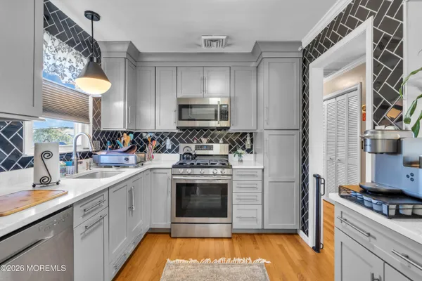 a kitchen with stainless steel appliances a stove a sink and a refrigerator