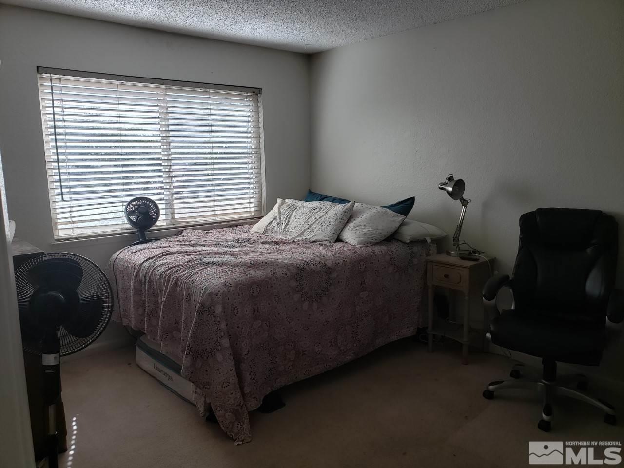 10044 Humite Lane Reno, NV 89506 - Photo 13 of 24 a bedroom with a bed and a window