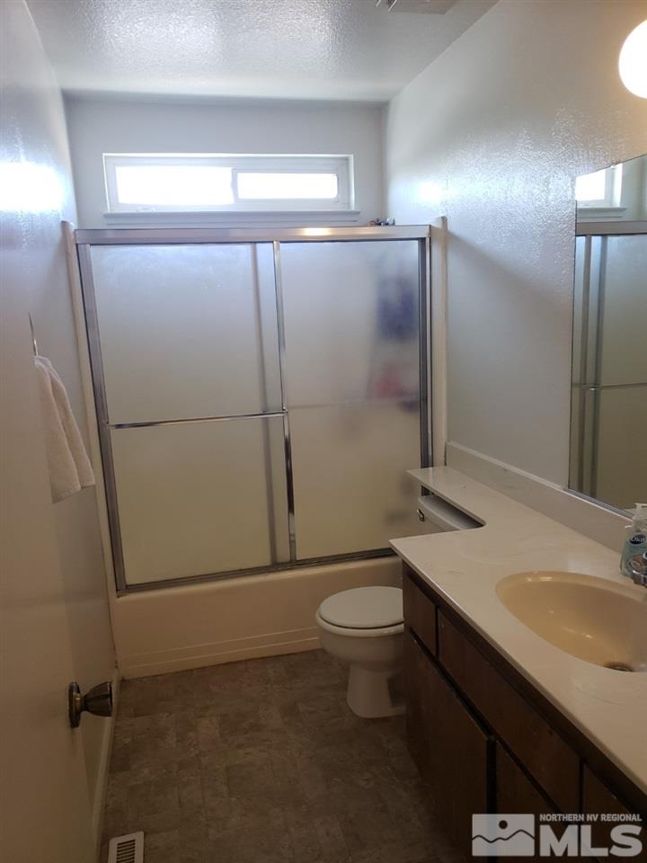 10044 Humite Lane Reno, NV 89506 - Photo 17 of 24 a bathroom with a sink a toilet a mirror and vanity
