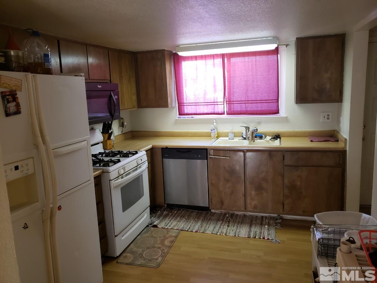 10044 Humite Lane Reno, NV 89506 - Photo 10 of 24 a kitchen with granite countertop a sink a stove and refrigerator