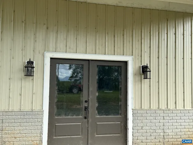 a front view of house with yard and trees in the background