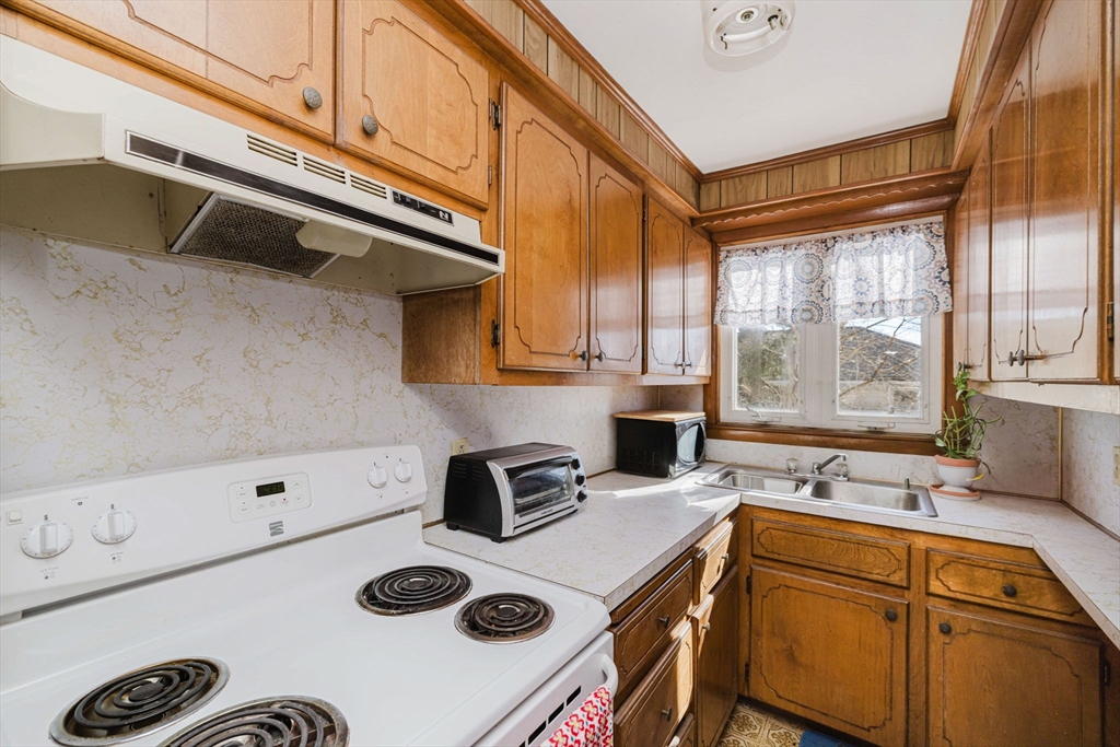 869 Bedford Street Fall River, MA 02723 - Photo 15 of 31 a kitchen with a stove a sink and a microwave