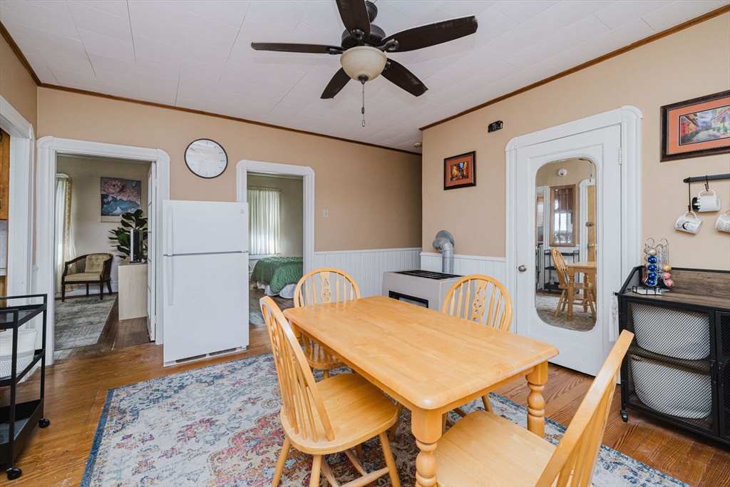 869 Bedford Street Fall River, MA 02723 - Photo 18 of 31 a dining room with wooden floor a chandelier fan a wooden table and chairs