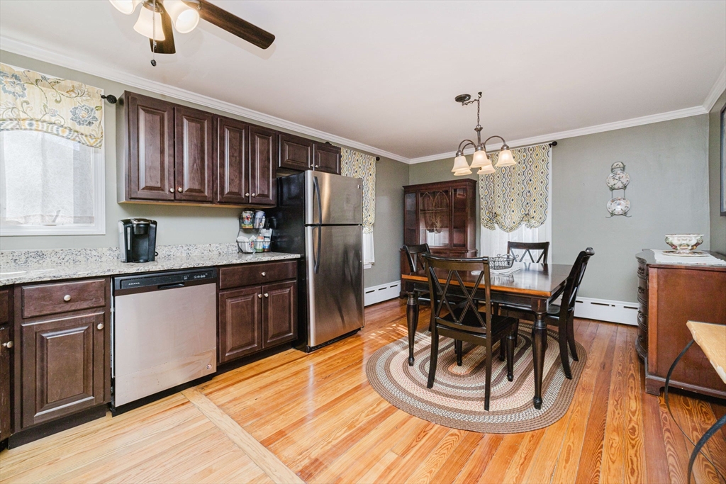 869 Bedford Street Fall River, MA 02723 - Photo 4 of 31 a kitchen with stainless steel appliances kitchen island granite countertop a dining table chairs and a refrigerator