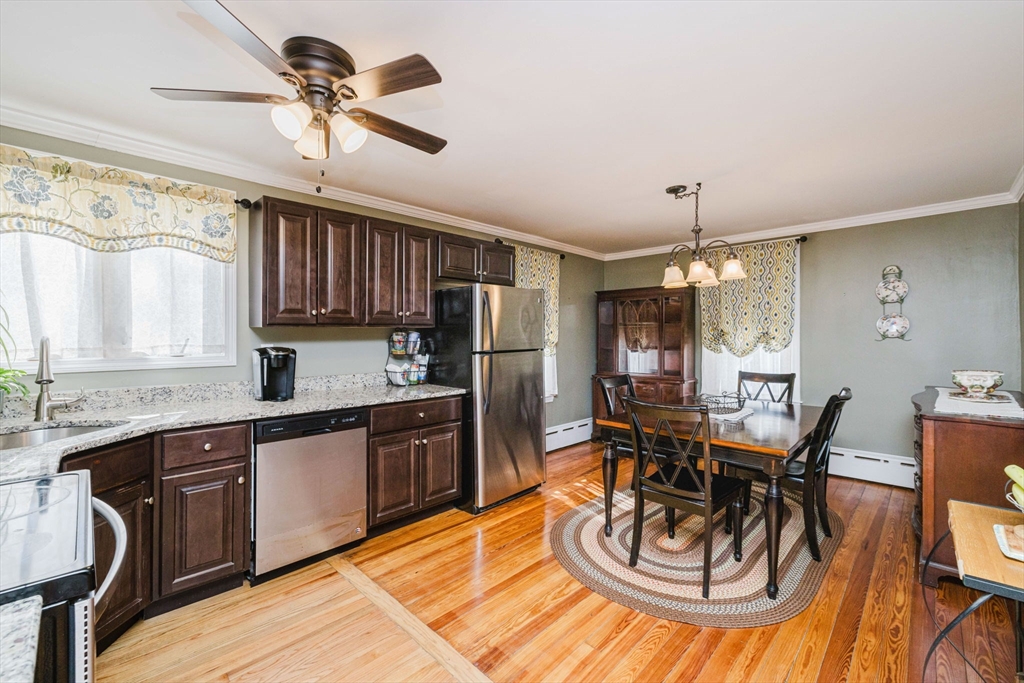 869 Bedford Street Fall River, MA 02723 - Photo 8 of 31 a kitchen with stainless steel appliances granite countertop a sink dishwasher a stove a refrigerator with a dining table and chairs