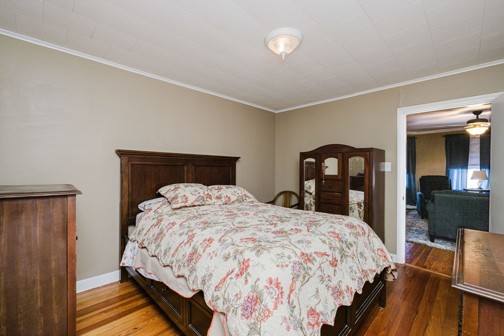 869 Bedford Street Fall River, MA 02723 - Photo 10 of 31 a bedroom with a bed and wooden floor