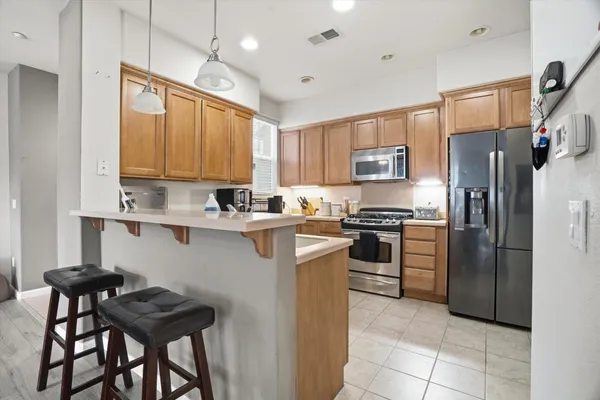 a kitchen with cabinets stainless steel appliances and a window