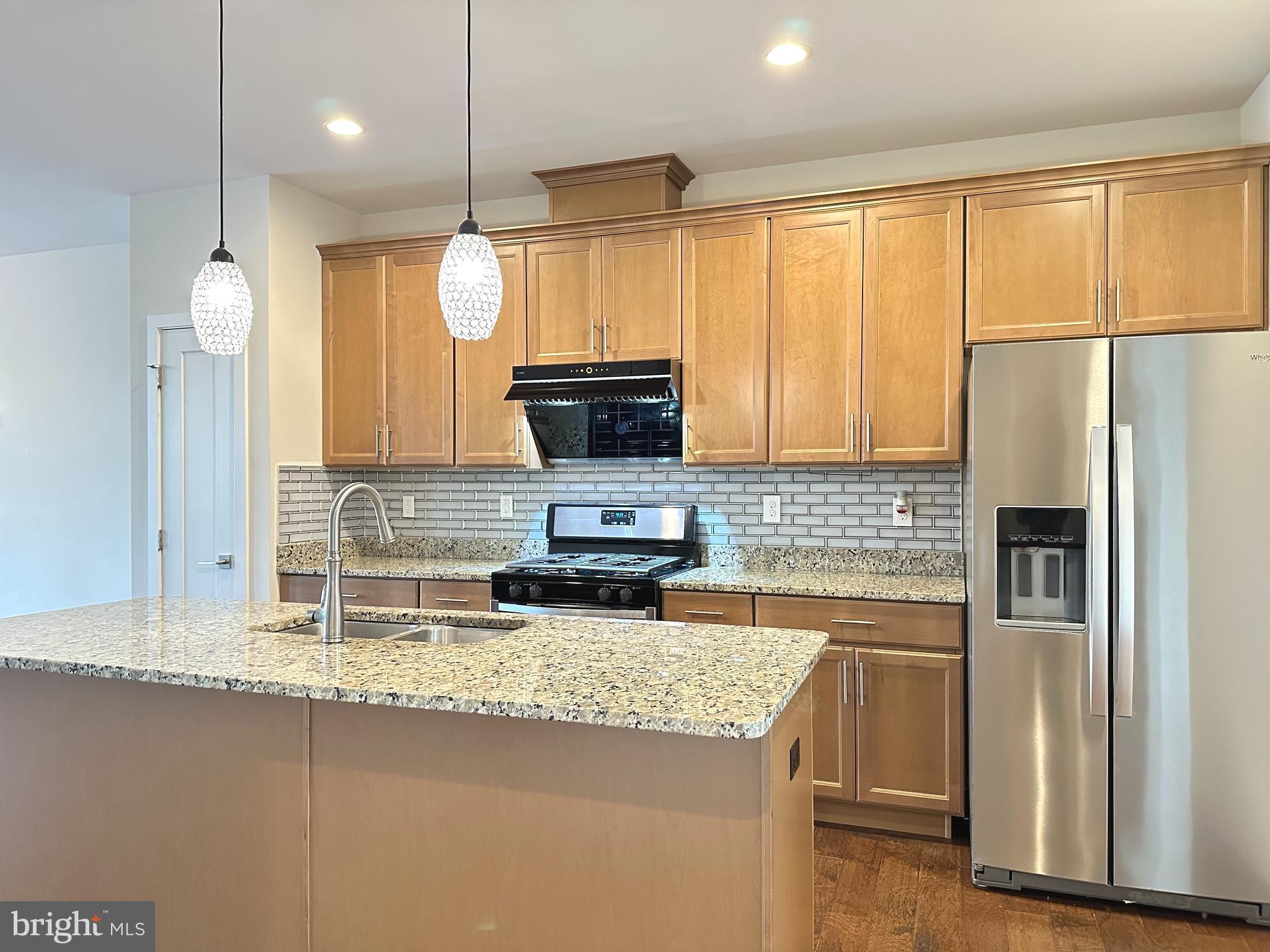303 Wynstone Court Colmar, PA 18915 - Photo 5 of 26 a kitchen with granite countertop a refrigerator a sink a stove and microwave