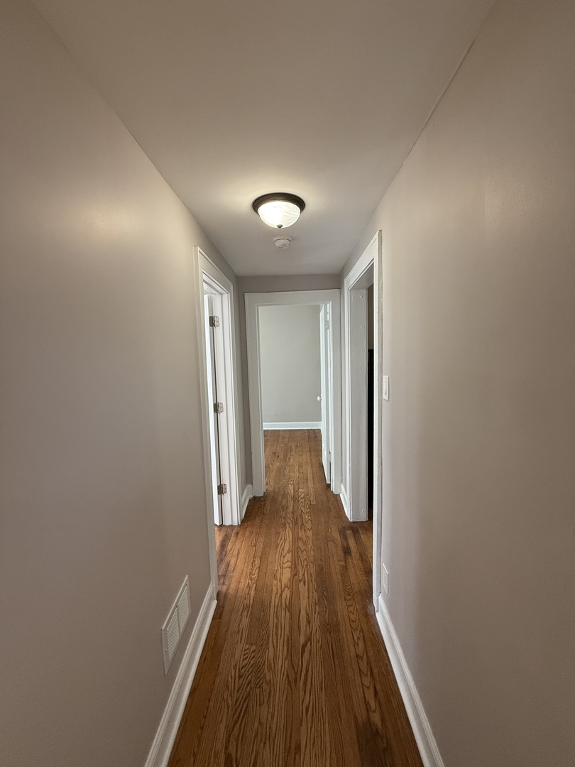 3901 West Division Street, Unit 1150 Chicago, IL 60651 - Photo 5 of 9 a view of a hallway with wooden floor