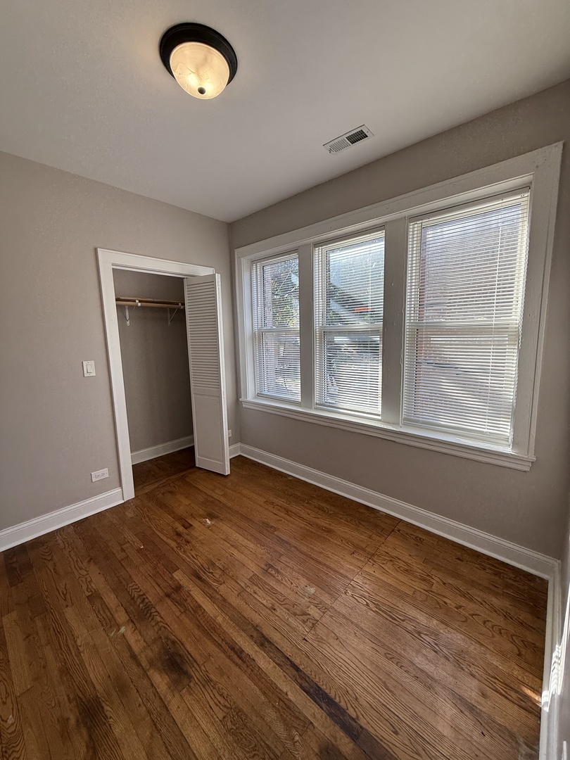 3901 West Division Street, Unit 1150 Chicago, IL 60651 - Photo 8 of 9 a view of an empty room with a window and wooden floor