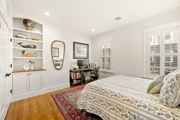 a bedroom with a bed a mirror and window