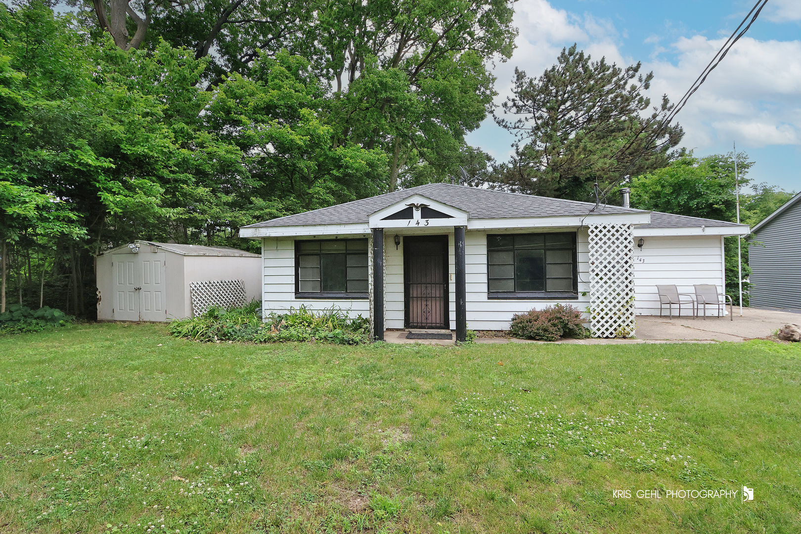 a front view of a house with a garden and trees