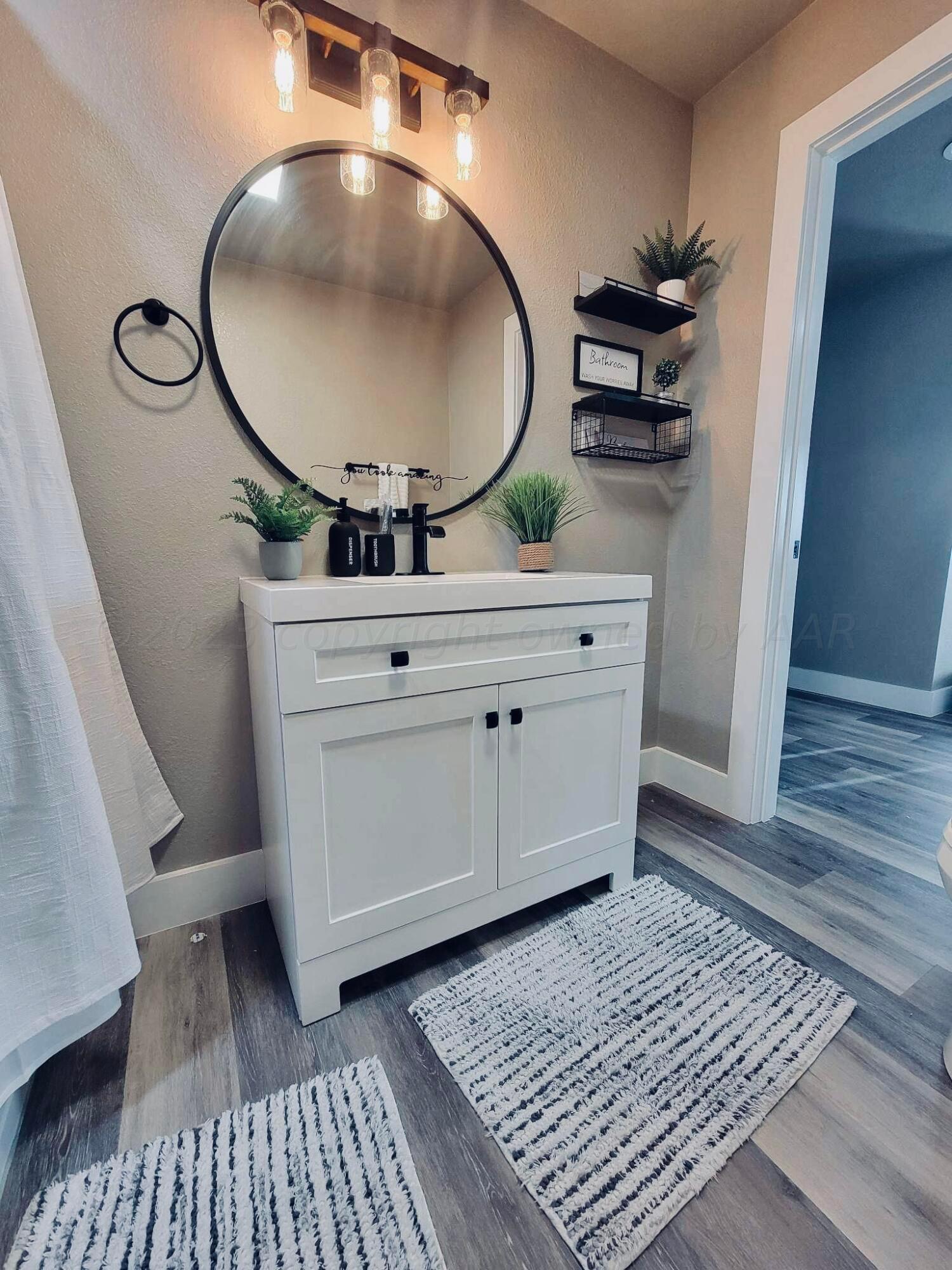 3501 Moss Lane Amarillo, TX 79109 - Photo 36 of 51 a bathroom with a mirror and a sink