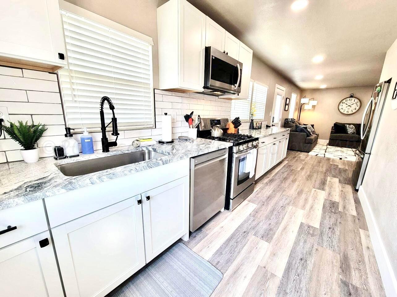 3501 Moss Lane Amarillo, TX 79109 - Photo 48 of 51 a kitchen with stainless steel appliances kitchen island granite countertop a sink and white cabinets
