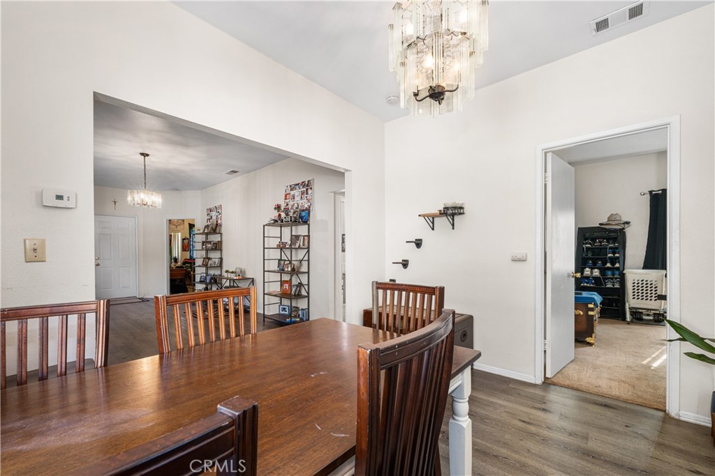 9722 Walnut Street Bellflower, CA 90706 - Photo 14 of 55 a view of a dining room and livingroom with furniture wooden floor a chandelier