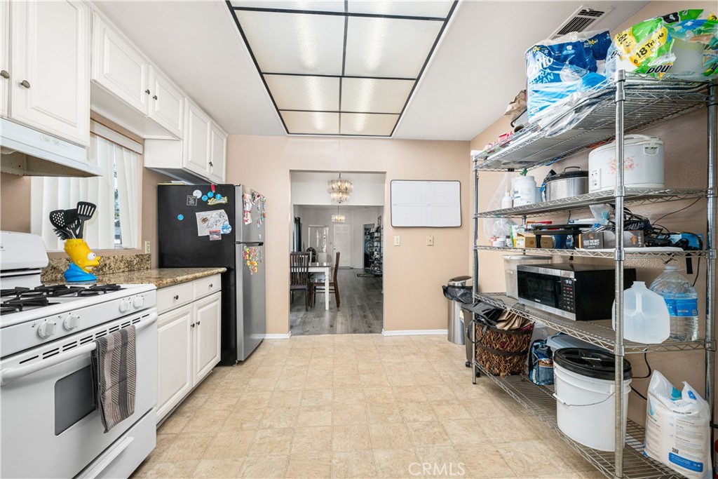 9722 Walnut Street Bellflower, CA 90706 - Photo 19 of 55 a kitchen with stainless steel appliances granite countertop a sink a stove and a refrigerator