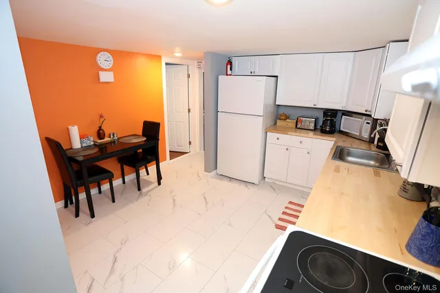 a kitchen with a refrigerator a stove and a dining table