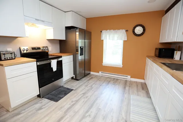 a kitchen with a refrigerator and a stove top oven