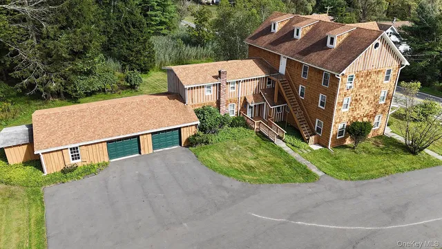 an aerial view of a house with swimming pool and large trees